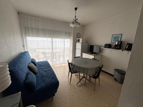 un salon avec un canapé bleu et une table dans l'établissement Appartement 26m² Sud/Est avec Balcon à Balaruc-les-Bains, Animaux acceptés - FR-1-503-69, à Balaruc-les-Bains