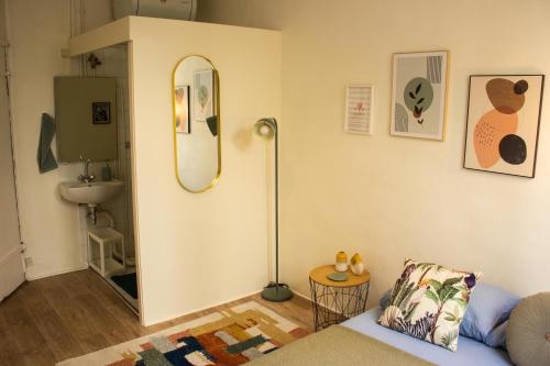 - un salon avec un miroir et un canapé dans l'établissement Saint Germain de Près tout équipé - Emplacement exceptionnel au Coeur de Paris, à Paris