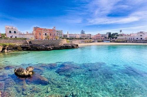 Attico nel cuore del Salento, un'oasi di relax في ناردو: مجموعة كبيرة من المياه مع المباني في الخلفية