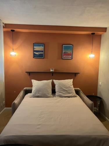 une chambre avec un lit avec deux oreillers dans l'établissement Studio cosy, piscine, parking, 5min plage, Arcachon, à Arcachon