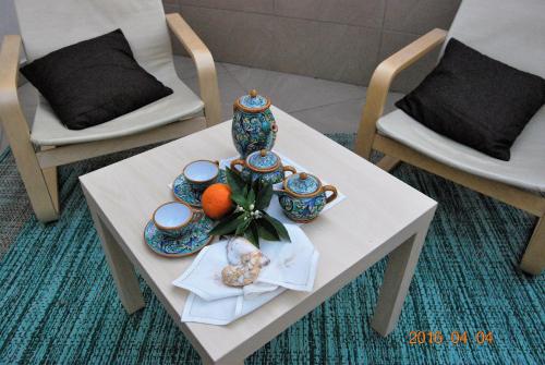 a white table with two chairs and a plate of fruit at Residence Rapisardi by RECEPTIO in Catania