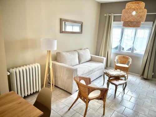 un salon avec un canapé, des chaises et une table dans l'établissement Maison confortable et élégante - 2 chambres - Berck-Plage, à Berck-sur-Mer