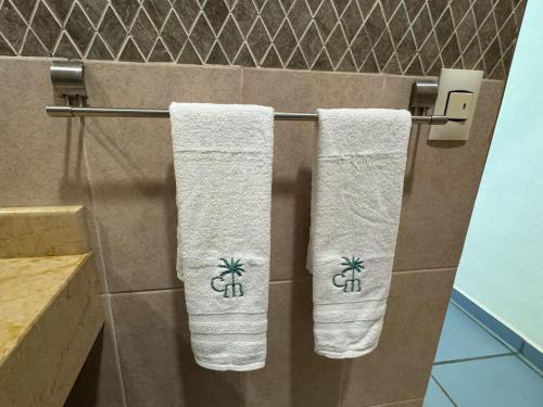 three towels hanging on a towel rack in a bathroom at Casa Mismaloya Selva in Cedro