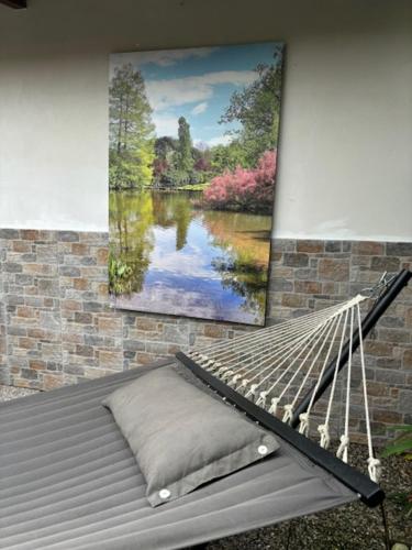 a hammock hanging on a brick wall with a painting at Mambo House in Milan