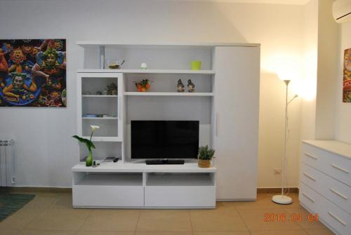 a living room with a tv on a white entertainment center at Residence Rapisardi by RECEPTIO in Catania
