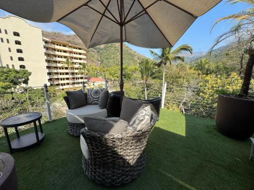 a patio with a chair and an umbrella at Casa Mismaloya Selva in Cedro