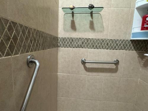 a bathroom with a tiled wall with a towel rack at Casa Mismaloya Selva in Cedro