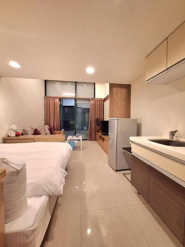 eine Küche mit einem Bett und einem Waschbecken in einem Zimmer in der Unterkunft Cafe溫泉屋 in Jiaoxi