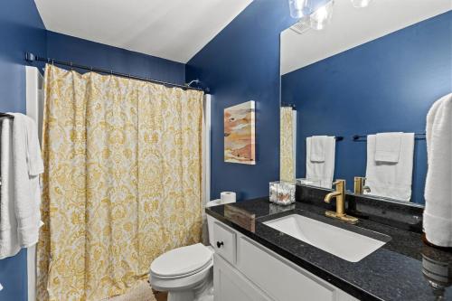 a blue bathroom with a sink and a toilet at The Luxe Hot Tub Playground 12 Min to Horse Park in Georgetown