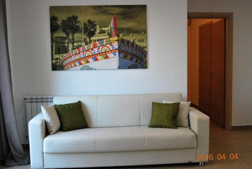 a white couch in a living room with a painting at Residence Rapisardi by RECEPTIO in Catania