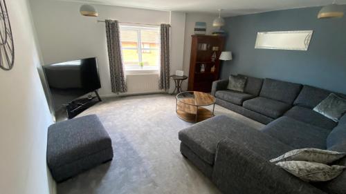 a living room with a couch and a tv at Southcliff Retreat in Scarborough