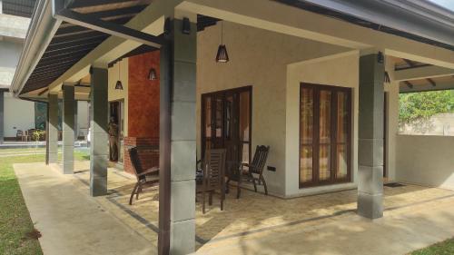 a porch of a house with chairs and a table at Noble Sight in Anuradhapura