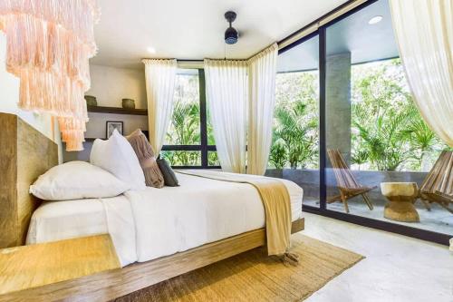 a bedroom with a large bed and a large window at Boho Jungle Villa -Pvt Pool -Concierge-Hammock 7B in Tulum