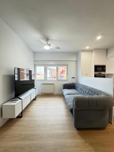 Una sala de estar con un sofá y un televisor. en Nohe, en Cuenca