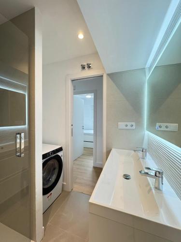 a bathroom with a sink and a washing machine at Nohe in Cuenca