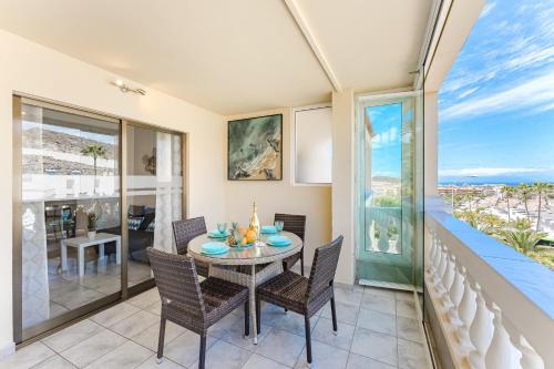 a dining room with a table and chairs and a balcony at Ocean Terrace Apartment in Los Cristianos
