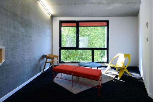 a room with a red bench and a window at Hôtel Belvue in Brussels
