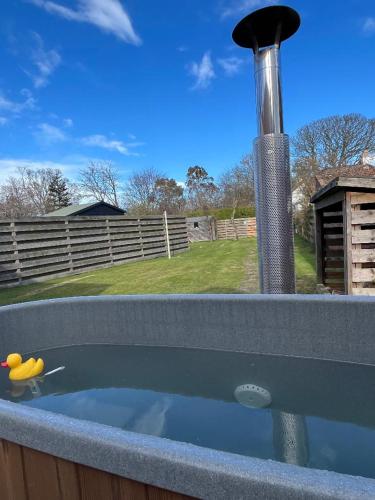 a hot tub with a pole in a backyard at Beach Cottage in a Tranquil Location in Kingsbarns