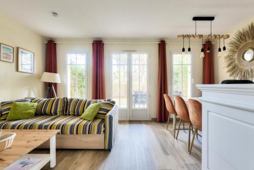un salon avec un canapé et une table dans l'établissement Les Maisons de Lacanau les Pins - maeva Home - Maison charmante avec jardin 3 pièces 4 personnes - Prestige - super Home MAE-7455, à Lacanau