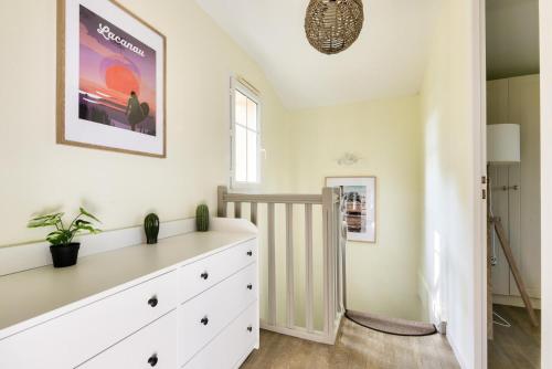 - une chambre avec une commode blanche et une fenêtre dans l'établissement Les Maisons de Lacanau les Pins - maeva Home - Maison charmante avec jardin 3 pièces 4 personnes - Prestige - super Home MAE-7455, à Lacanau