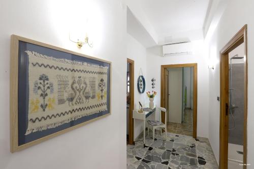un corridoio con un dipinto sul muro e un tavolo di Sofia's Casita ad Alghero
