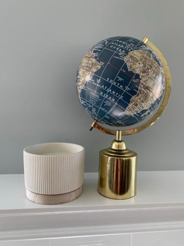 a globe on top of a shelf next to a cup at Spacious Drumheller-RetreatMuseum & Golf in Drumheller