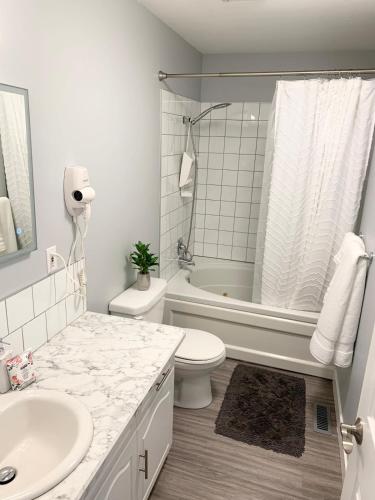 a white bathroom with a sink and a toilet at Spacious Drumheller-RetreatMuseum & Golf in Drumheller