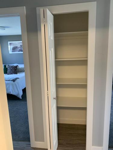 a bedroom with a closet with a door open at Spacious Drumheller-RetreatMuseum & Golf in Drumheller