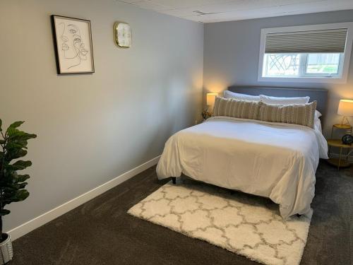 a bedroom with a large bed and a rug at Spacious Drumheller-RetreatMuseum & Golf in Drumheller