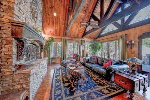 a living room with a couch and a stone fireplace at 9-Bedroom Atlanta Mansion for Rentals and Events in Marietta