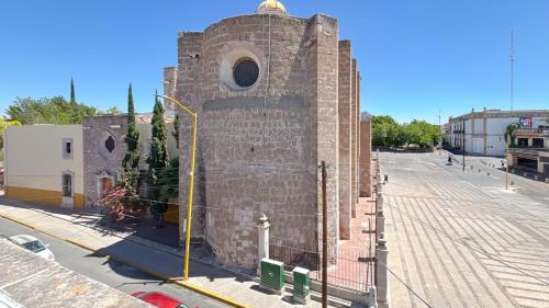 a tall brick building with a window on a street at Gardenia Roof Hostel in Aguascalientes