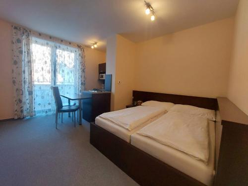 a bedroom with a bed and a table with a chair at Apartman Panorama 329 in Štrbské Pleso