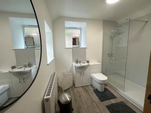 a bathroom with two sinks and a shower and a toilet at Cil-y-Coed in Dolgellau