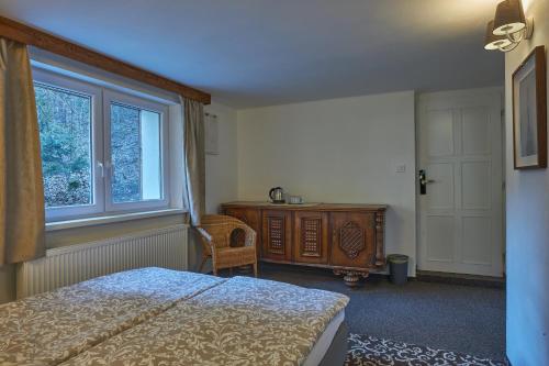a bedroom with a bed and a dresser and a window at Penzión MALINO in Ružomberok