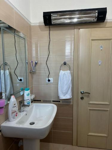 a bathroom with a sink and a mirror at Vasil's Apartment in Gjirokastër