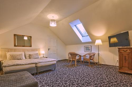 a bedroom with a bed and a table with chairs at Penzión MALINO in Ružomberok