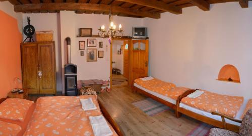 een woonkamer met 2 bedden en een kroonluchter bij Chalupa Sonja in Lúčky
