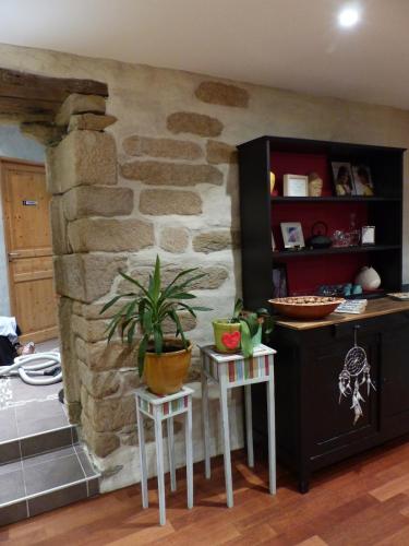 une cuisine avec deux tables et un mur en pierre dans l'établissement longère spacieuse au calme, superbe vue mer, à Loc-Maria-Plouzané