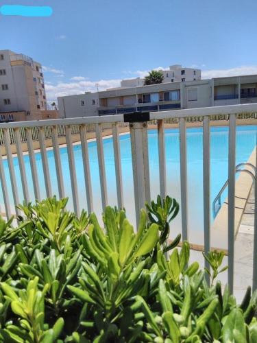 une clôture avec vue sur la plage et un bâtiment dans l'établissement Appartement aéré avec vue sur la mer , plage 50m et piscine 20m dans la résidence, au Barcarès