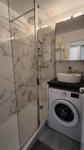une salle de bain avec une machine à laver et un lavabo dans l'établissement Résidence le Hameau de Cap Esterel - maeva Home - Studio vue mer 4 personnes - Sélection - super Home MAE-2721, à Saint-Raphaël