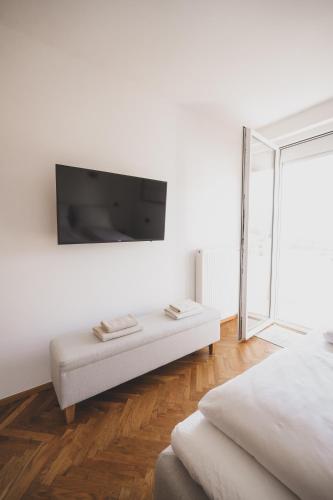 a white room with a flat screen tv on the wall at "Schloss Ort Blick" Apartment in Gmunden