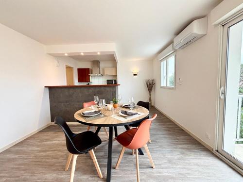 une salle à manger et une cuisine avec une table et des chaises dans l'établissement L'Éclatant, Lumineux, Centre-ville, à Royan