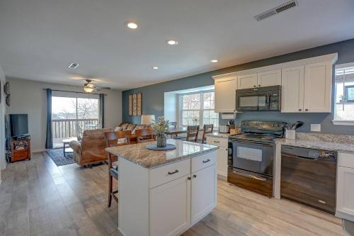 a kitchen with white cabinets and a living room at Steps to Table Rock Lake, Min to Silver Dollar City in Branson