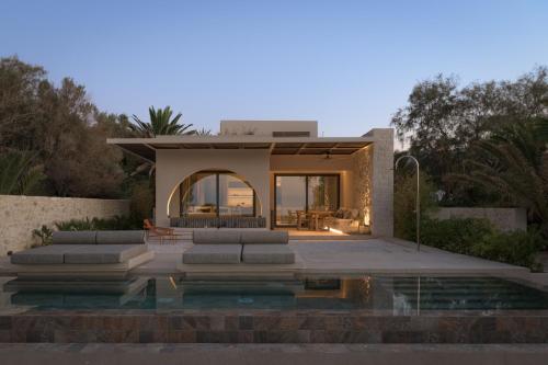 a house with a pool in front of it at Dyo Beach Suites in Rethymno Town