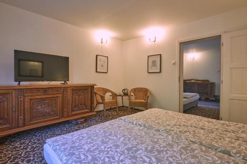 a bedroom with a bed and a flat screen tv at Penzión MALINO in Ružomberok