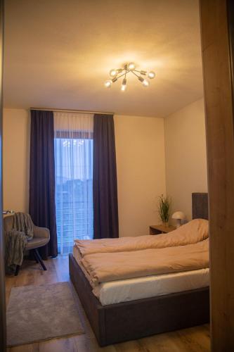 a bedroom with a large bed and a window at Mint Vibe Apartment in Odorheiu Secuiesc