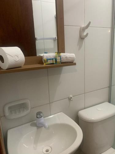 a bathroom with a white toilet and a sink at Pousada Morada in Aparecida
