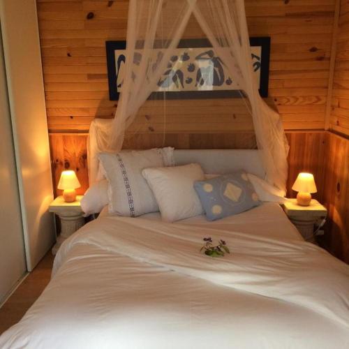 - une chambre avec un lit blanc et 2 lampes dans l'établissement Cottage provençal 3 chambres piscine spa nature & calme, à Colomars