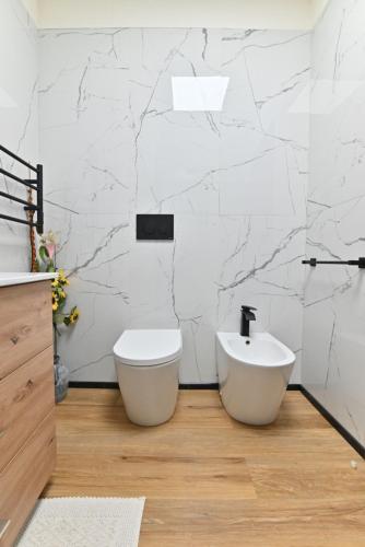 a white bathroom with a toilet and a sink at casa vacanze edwige castello in Cagliari