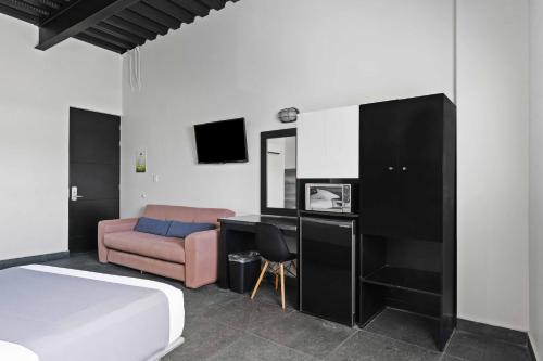 a bedroom with a bed and a desk and a couch at Homesuites Malecon in Culiacán